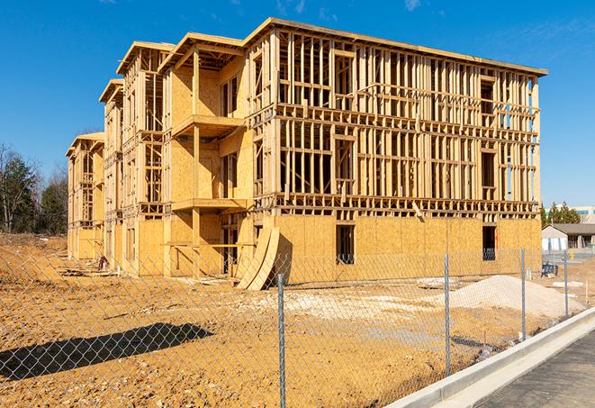 a temporary chain link fence winding around a construction site, outlining the project's progress in Charles City IA